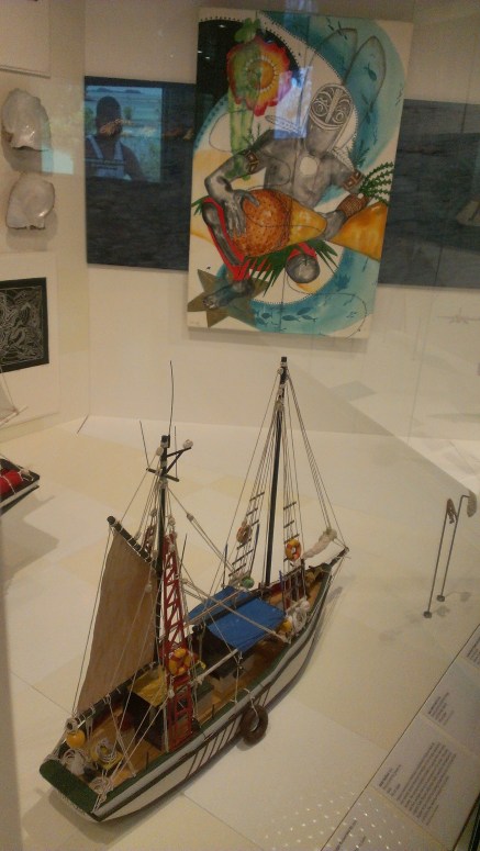 A model pearling lugger in the foreground with a Marie Jose oil painting behind in the transition between stories on the marine harvesting industries and Torres Strait in World War Two